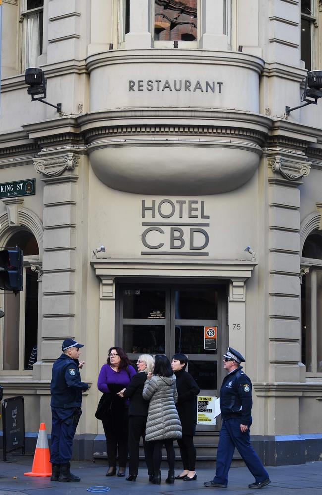 Police speak to people outside a hotel at the crime scene after a man stabbed a woman and attempted to stab others in central Sydney. Picture: AAP