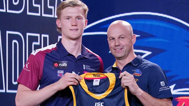 No.6 pick Fischer McAsey is presented with his Adelaide jumper by Matthew Nicks at the national draft. Picture: AAP