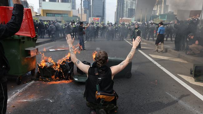 Anti-war activists set fire to bins as police close in. Picture: Jake Nowakowski