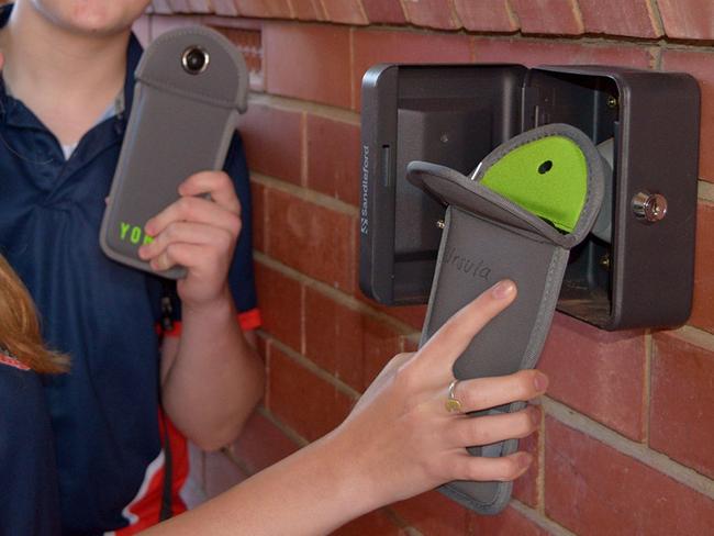 2021 Student Leaders Ursula Clarke and Ned Moxey unlock their Yondr pouches at one of several unlocking stations that have been installed around the PLHS campus. Pic: Supplied