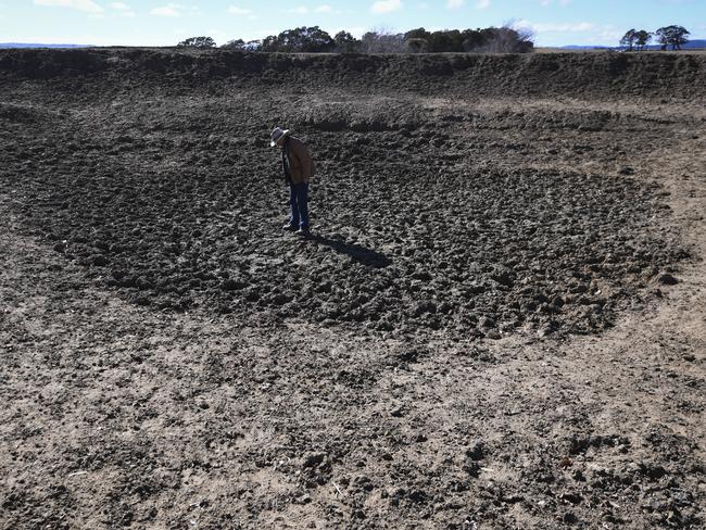 NSW farmer Mark Horan inspects a dried out dam on Bedervale farm near Braidwood, NSW. Picture: Lukas Coch