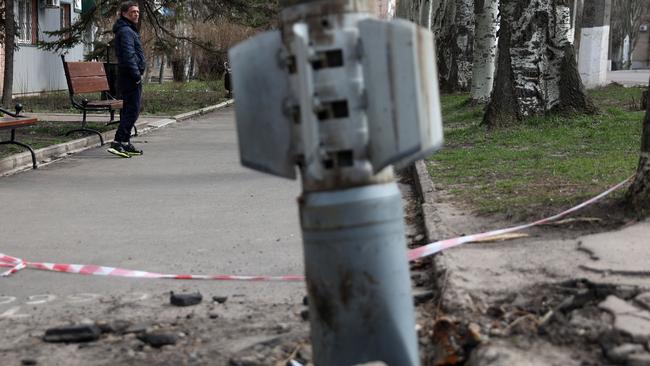 A man walks past an unexploded tail section of a 300mm rocket embedded in the ground after shelling in Lysychansk, Lugansk region, Ukraine. The United States will now supply Ukraine with controversial cluster munitions. Picture: AFP