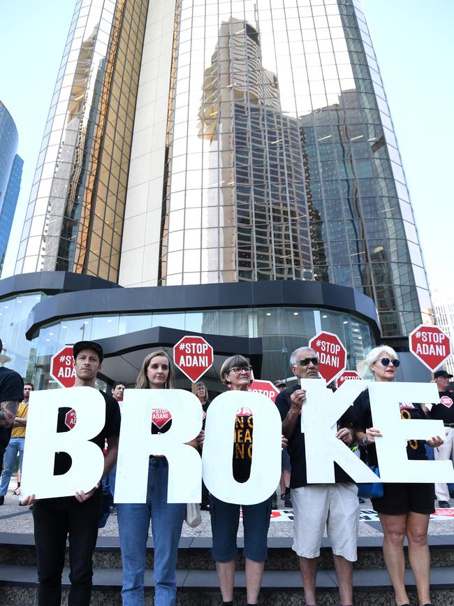 Anti-Adani protesters hold signs outside the company's offices in Brisbane yesterday Picture: Dan Peled/AAP