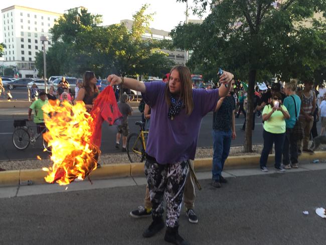 A protester holds a burning T-shirt as hundreds rally against Trump. Picture: Russell Contreras