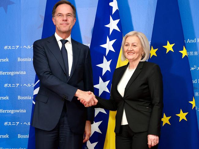 Chair woman of Bosnia and Herzegovina's Council of Ministers, Borjana Kristo (R), and Secretary General of NATO Mark Rutte, shake hands as they arrive to an official meeting. (Photo by AFP)