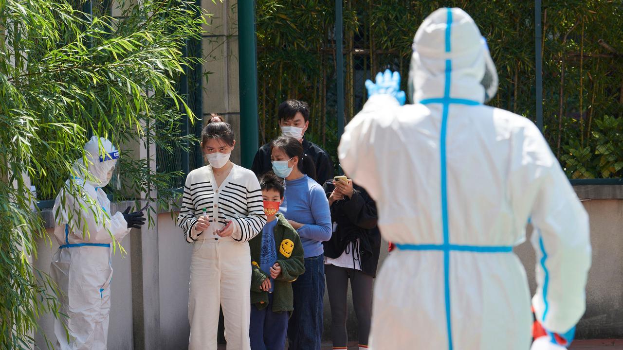 Community volunteers wearing personal protective equipment guide residents queuing to get tested for the Covid-19 coronavirus in a compound during a Covid-19 lockdown in Shanghai. Picture: AFP.