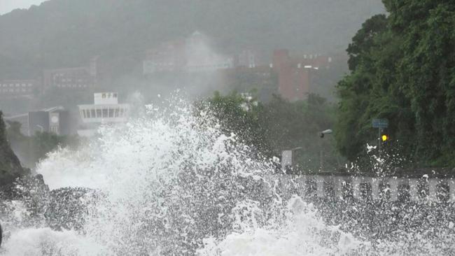 A car drives past a fallen tree as Typhoon Krathon nears Kaohsiung on October 3