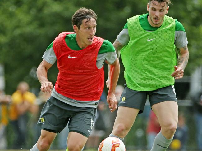 Mark Milligan gets around Chris Herd at Socceroos training.