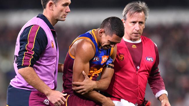 Charlie Cameron is helped off the Gabba.