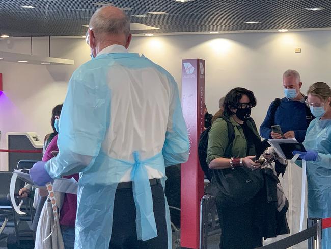 NSW Health workers dressed in Personal Protection Equipment greet passengers travelling from Perth on Virgin flight VA552 at Sydney Airport. Picture: NCA NewsWire/Bianca De Marchi