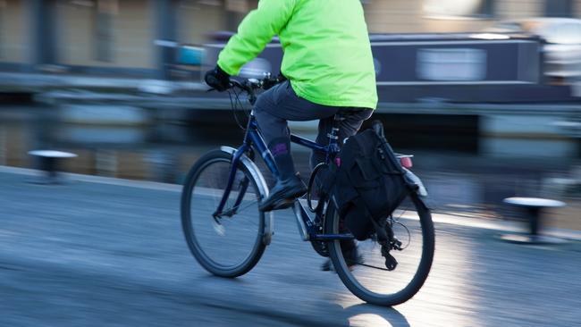 A person cycling down a cannal walkway