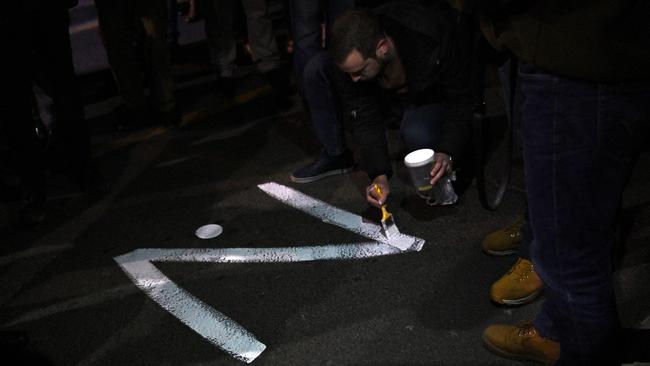 A protester paints the ‘Z’ sign on a street during a pro-Russia rally. Picture: Andrej Isakovic/AFP