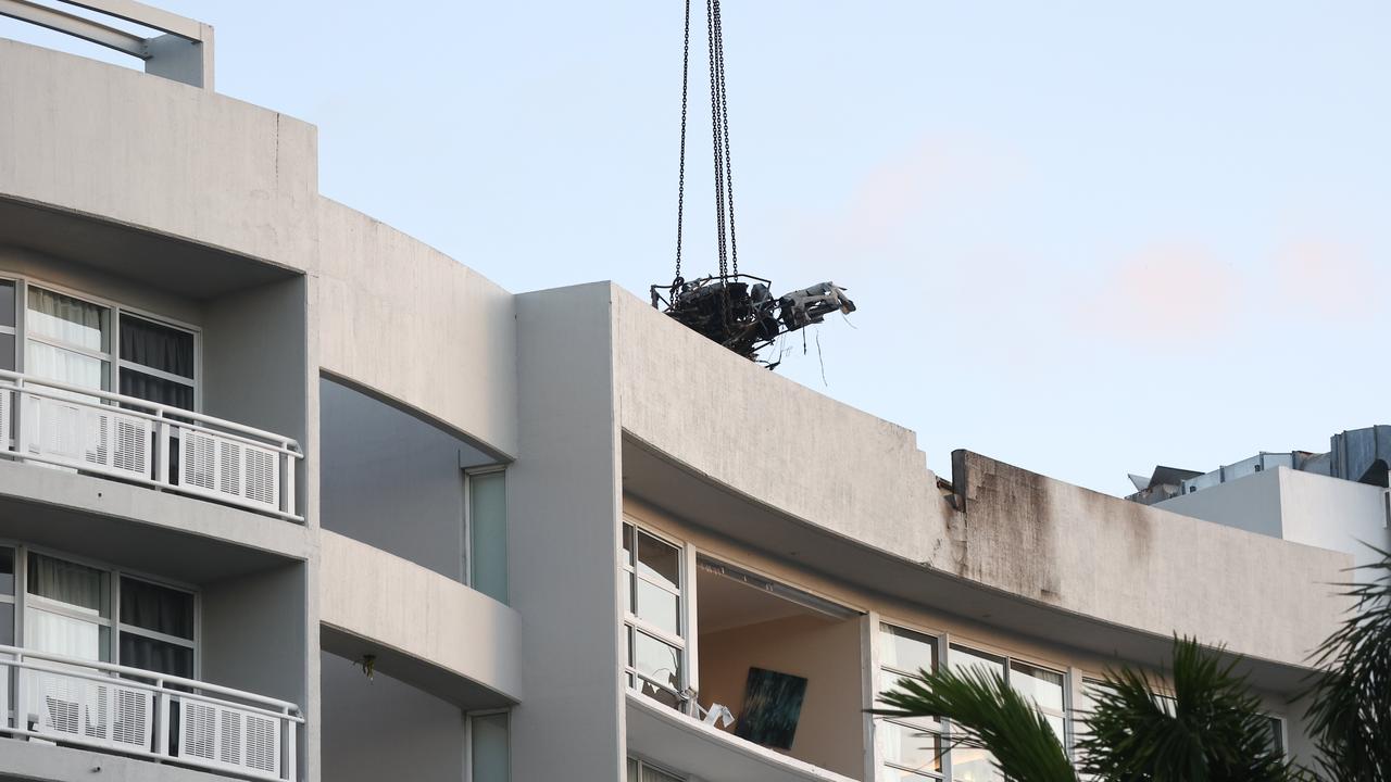 A large crane lifts the wreckage of the helicopter off the roof top of the Double Tree Hilton hotel into a skip bin. Picture: Brendan Radke