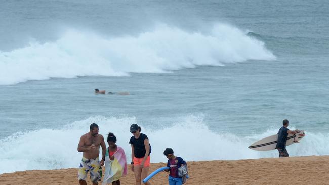 A family walk along Narrabeen beach as the Northern Beaches battles with a Covid cluster. Picture: NCA NewsWire / Jeremy Piper