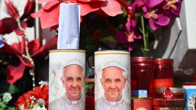 A hand written message is placed in a candle of Pope Francis outside the Gemelli hospital where Pope Francis is staying.