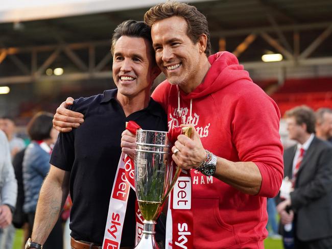 WREXHAM, WALES - APRIL 26: Rob McElhenney and Ryan Reynolds, co-owners of Wrexham AFC, pose for a photo with the trophy following the club's promotion to the Sky Bet Championship during the Sky Bet League One match between Wrexham AFC and Charlton Athletic FC at Racecourse Ground on April 26, 2025 in Wrexham, Wales. (Photo by Kya Banasko/Getty Images)