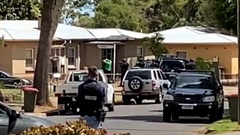 A police officer brandishes a weapon as two people are arrested. Picture: Facebook