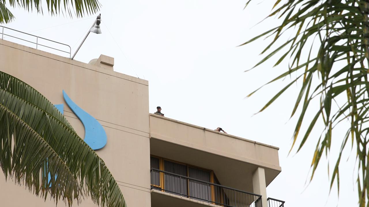 Police keep an eye on the crowd from the roof of the Pacific Hotel. Picture: PETER CARRUTHERS