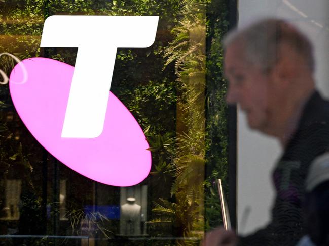 A man walks past the office of Australian telecoms company Telstra in the central business district of Sydney on May 21, 2024. Leading Australian telecoms company Telstra said May 21 it would slash up to 2,800 jobs, shedding nine percent of its workforce as it keeps pace with "rapid advances in technology". (Photo by Saeed KHAN / AFP)