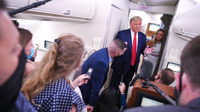 US President Donald Trump, flanked by White House press secretary Kayleigh McEnany, right, speaks to reporters while in flight after a campaign rally in Pensacola, Florida, on Friday US time. Picture: AFP