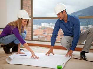 Architects at a construction site looking at the blueprints. Picture: andresrimaging