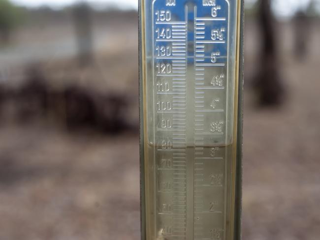 Rain Gauge with water reaching to the 80mm mark. Felton Farmer Paul Fuhlbolm enjoy the pool of water and the mud with his children Erin 5yr and Jack 2yr. at the family 800acre property 162km southwest of Brisbane. Property received 80mm of rain overnight from 5pm Friday afternoon. (contact: 0427935953) 18th January 2020. pic David Martinelli