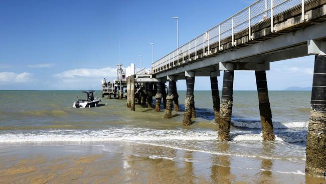 The lowest tide of the year has seen a lot of sand exposed on Palm Cove beach and left the jetty pylons high and dry. Picture: Brendan Radke