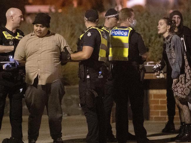 Police arrest a man at St Kilda beach on New Year's Eve. Picture: David Geraghty