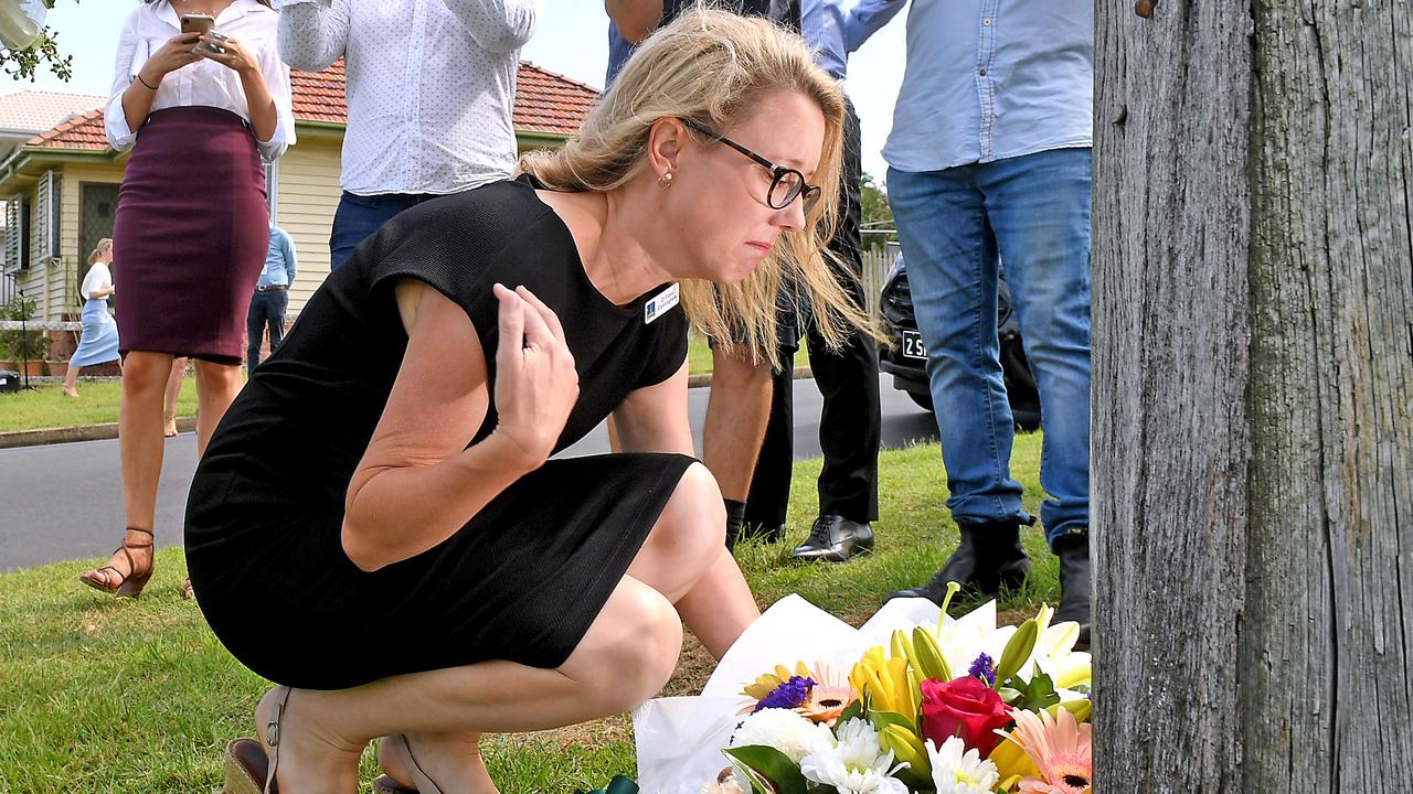 Coorparoo member Fiona Cunningham leaves flowers on Raven Street in Camp Hill. Picture: AAP/John Gass