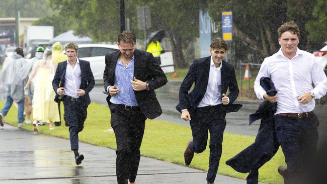 People rushing for cover on a wet Magic Millions Race day at Gold Coast Turf Club, Saturday, January 11, 2025. Picture: Richard Walker