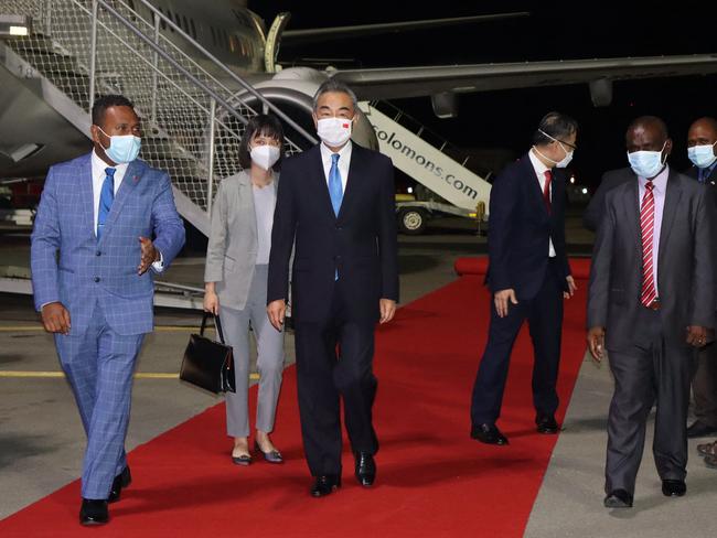 This picture taken on May 25, 2022, shows Solomon Island's Foreign Minister Jeremiah Manele (L) escorting Chinese Foreign Minister Wang Yi (C) upon his arrival at the Henderson International Airport in Honiara. (Photo by STRINGER / AFP)