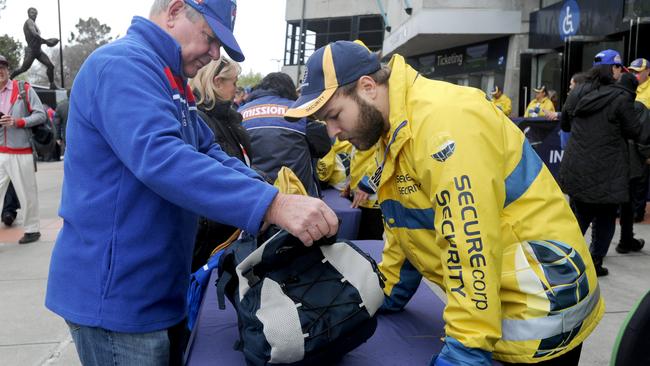 Security guards check bags as fans enter the MCG. Picture: Andrew Henshaw