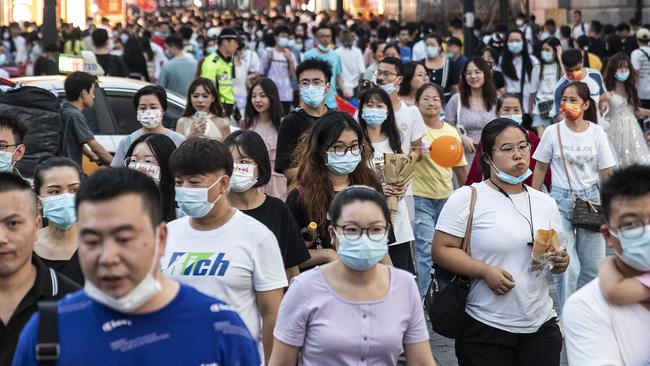 People wear masks while walking along a street in the Chinese city of Wuhan. Picture: Getty Images