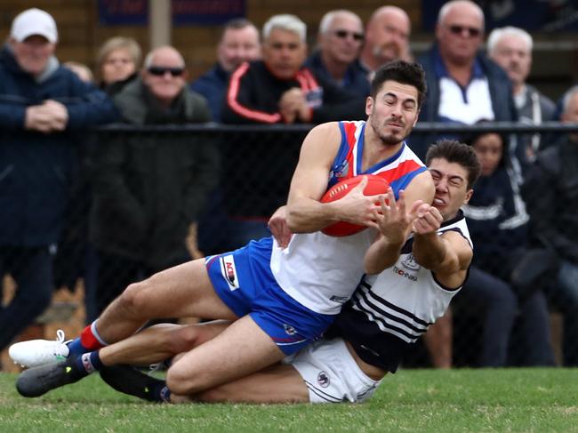 Patrick Karnezis slides into a mark against Bundoora. Picture: Mark Dadswell