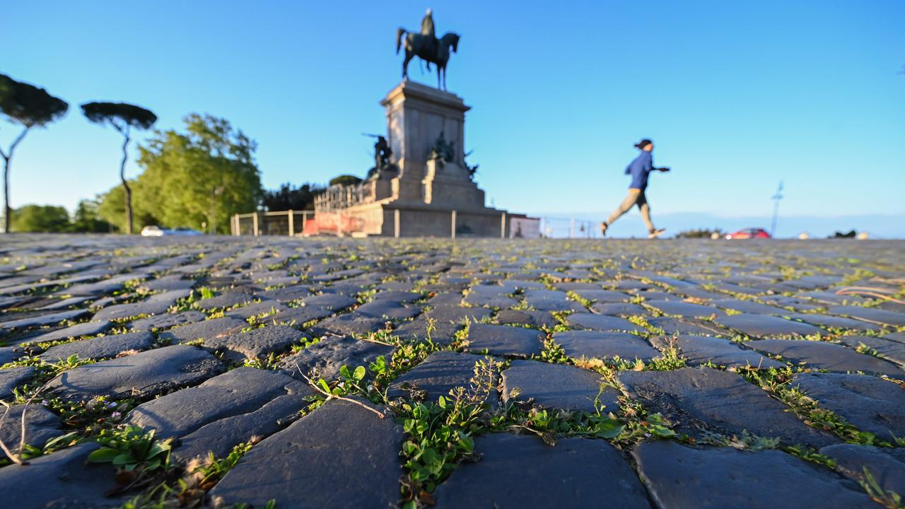 Grass grows between the road's cobblestones as a woman jogs past the equestrian statue of Giuseppe Garibaldi on April 26, 2020 at the Gianicolo terrace overlooking Rome. Picture: Andreas Solaro/AFP