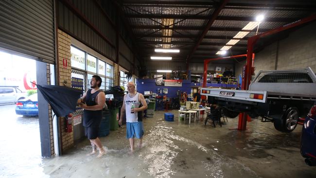 Major flooding in Currumbin Creek rd at Currumbin. Ben Freriechs and Dylan Coleman from Sel's autos watch the crisis unfold with a beer. Picture Glenn Hampson