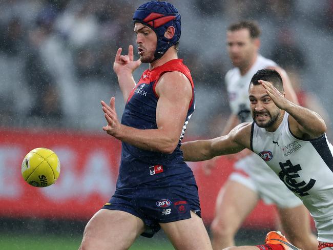 Melbourne’s Angus Brayshaw gets a kick away ahead of Blue Michael Gibbons. Picture: Michael Klein