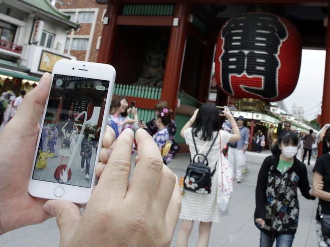 A man tries to catch a Pikachu while he plays Pokemon Go in front of Thunder Gate at the Sensoji temple in Asakusa, Tokyo. Picture: AP