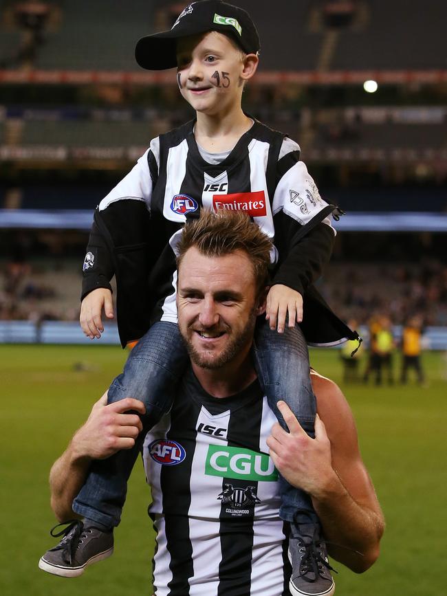 Lynden Dunn and his son Emmett after his first win as a Magpie. Picture: Michael Klein