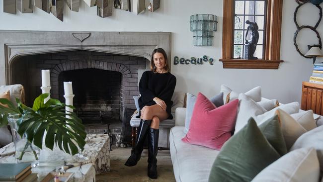 Tamsin Johnson in her home with vintage sculpture behind her.