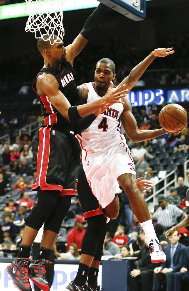 Atlanta Hawks forward Paul Millsap passes around Chris Bosh.