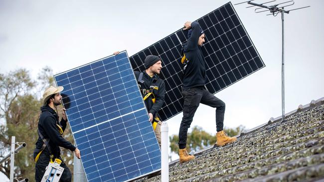 Workers install solar panels on a suburban Melbourne roof. Picture: Mark Stewart