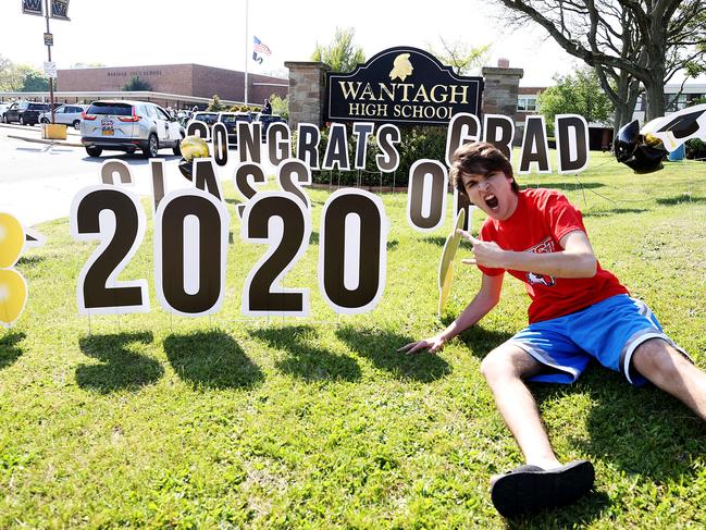 WANTAGH, NEW YORK - MAY 15: John Sileo, Wantagh High School Class of 2020 Co-President poses in front of a sign on the grass as graduating Seniors from Wantagh High School drive by the front of the school and their teachers cheer for them on May 15, 2020 in Wantagh, New York. In-person learning for the school semester has been cancelled and students will finish their year with online video classes due to the coronavirus COVID-19 pandemic.   Al Bello/Getty Images/AFP == FOR NEWSPAPERS, INTERNET, TELCOS & TELEVISION USE ONLY ==