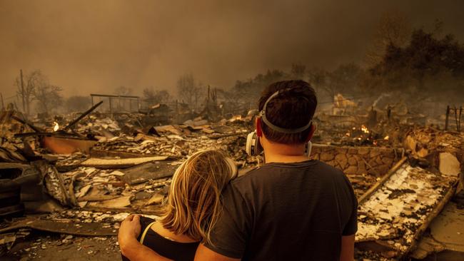 Megan Mantia, left, and her boyfriend Thomas, return to her fire-damaged home after the Eaton Fire swept through. Picture: AP