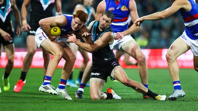 Bulldog Ed Richards tries to evade Power veteran Travis Boak. Picture: Daniel Kalisz/Getty Images