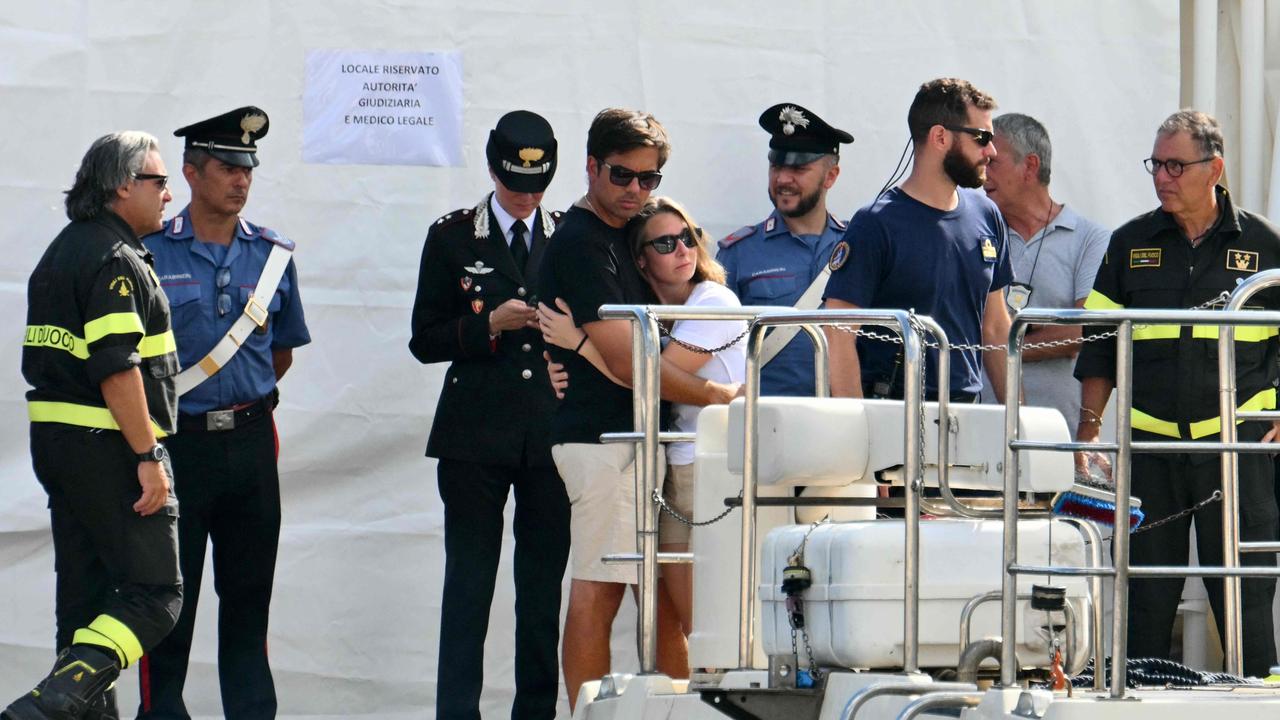 People hug each other on the pier of Porticello near Palermo, on August 22 three days after the British-flagged luxury yacht Bayesian sank. Picture: Alberto Pizzoli/AFP