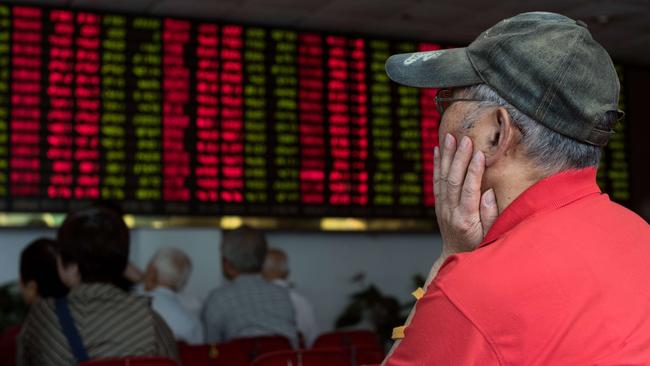 Investors monitor stock market movements at a brokerage house in Shanghai.