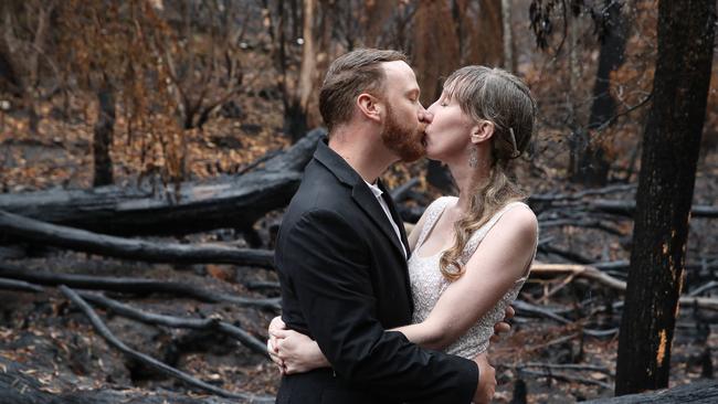 Lovebirds John Huckins and Teegan Diamond kissing in the rain among the burnt trees at the gardens, known among locals as the Rhodo Gardens. Picture: David Swift