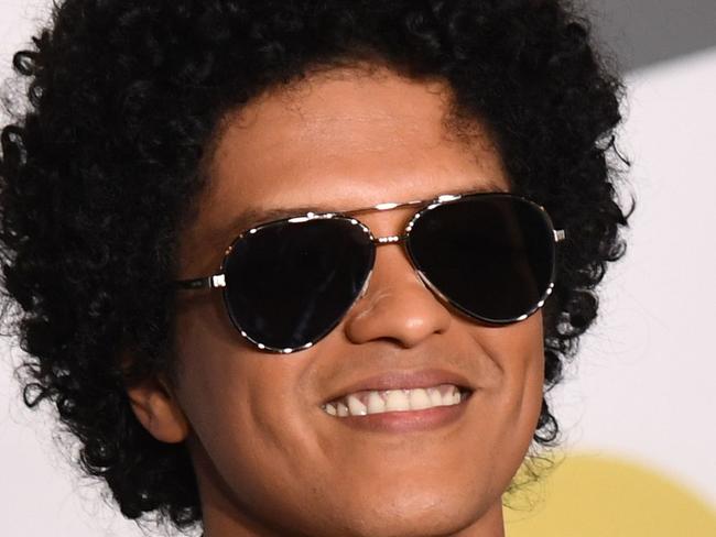 TOPSHOT - Singer Bruno Mars poses in the press room with his Grammy trophies during the 60th Annual Grammy Awards on January 28, 2018, in New York. / AFP PHOTO / Don EMMERT