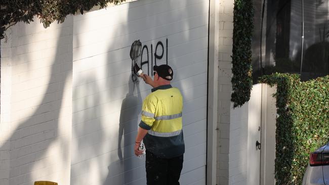 A council worker removes one of the slogans.